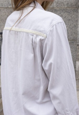 woman in cream button-up and brown pants