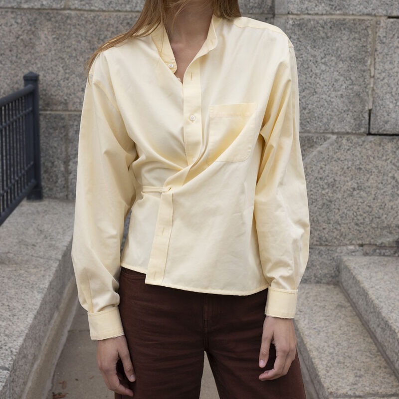 woman in pale yellow button-up wrap top and brown pants