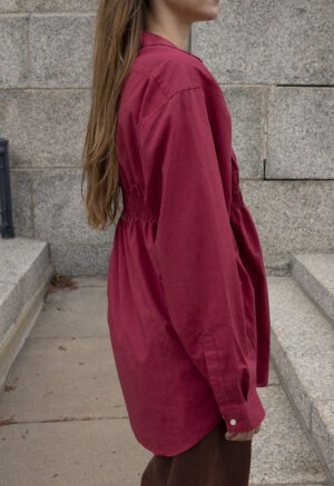 woman in red button-up and brown jeans