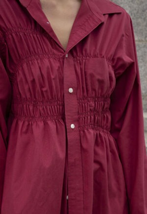 woman in red button-up and brown jeans