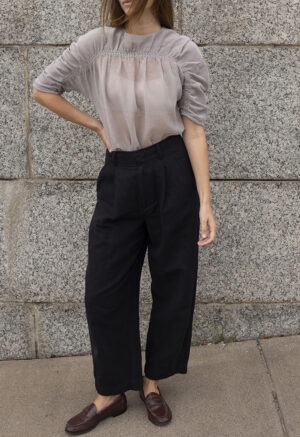 woman in shear ruched top and black trousers